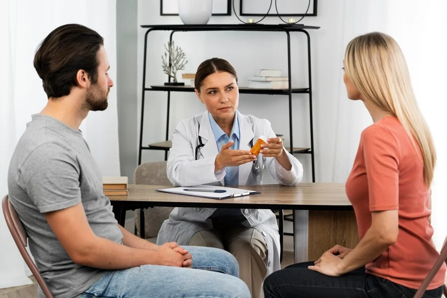 A doctor discussing mental health medical billing with a patient in a room.