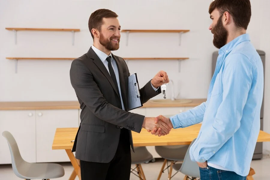 Two men shaking hands in an office, discussing credentialing for the provider.