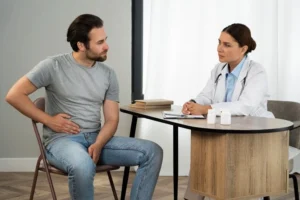 A man and woman sit at a table with a doctor, discussing Gastroenterology.