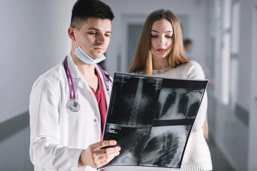A male doctor and a female patient examining an x-ray about the Chiropractic