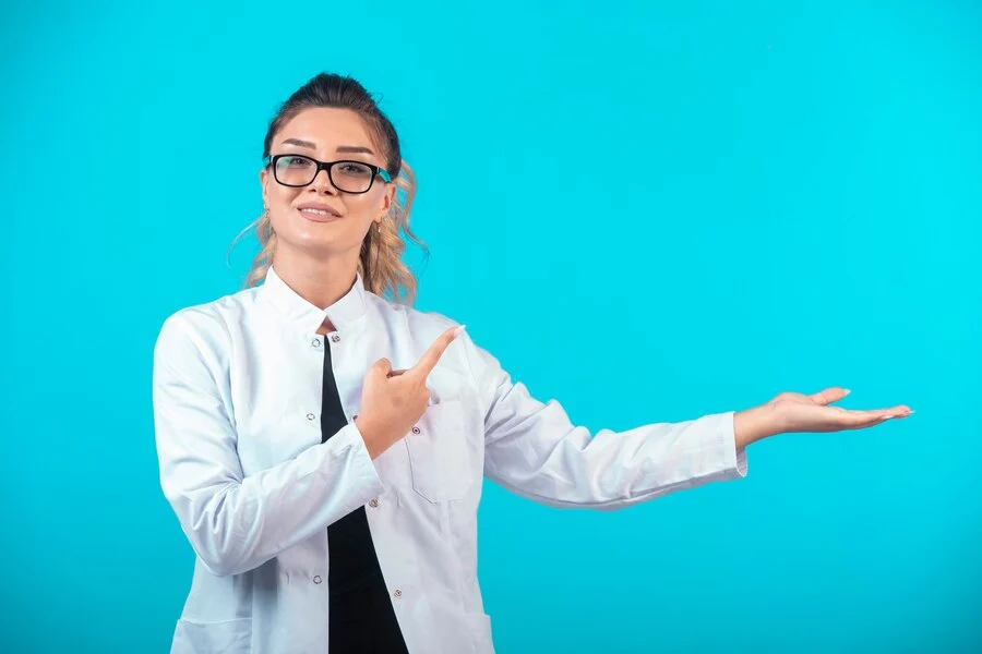 A woman wear a wihte coat and sunglasses stand with board discuss about the BPH ICD-10 codes.